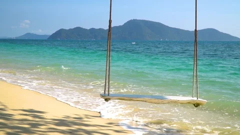 Close-up of a rope swing hanging on the beach with turquoise water. Stock Footage 85569195