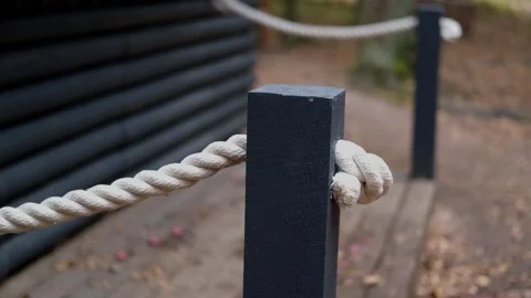 Close-up of rope tied to post, camera pans to reveal surrounding environment Stock Footage 322071135