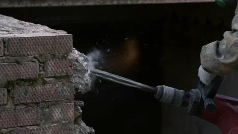 Close-up. Rotary Hammer breaks a wall of concrete. Slow motion. Pieces of Stock Footage 133295080