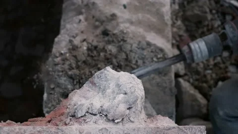 Close-up. Rotary Hammer breaks a wall of concrete. Slow motion. Pieces of Video stock 133295135