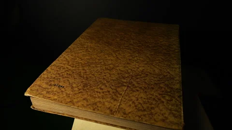 Close Up of Rotating Antique Book on Black Background in 50p Stock Footage 337708683