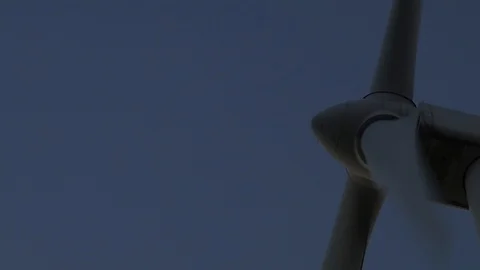 Close up of rotating blades of wind mill in the sunset light. Blue cast. Eco  Stock Footage 93368372
