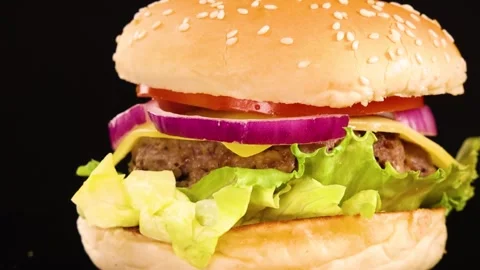 Close Up Rotating Cheeseburger with Fresh Toppings on Black Background Stock Footage 329740875