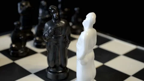 Close-up, on a rotating chessboard are black and white figures Video stock 124827090