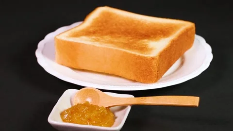 Close-up of rotating crispy toast and yuzu jam Stock Footage 325634331
