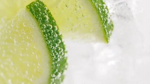 Close up of rotating fresh sliced fruit in glass with water and ice cubes. 4k ma Stock Footage 108059994