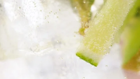 Close up of rotating fresh sliced fruit in glass with water and ice cubes. 4k ma Stock Footage 108060301