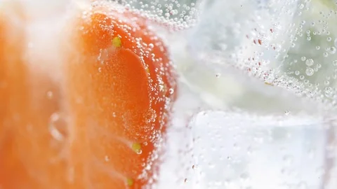 Close up of rotating fresh sliced fruit in glass with water and ice cubes. 4k ma Stock Footage 108060551
