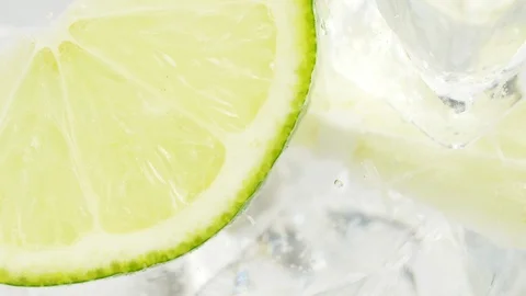 Close up of rotating fresh sliced fruit in glass with water and ice cubes. 4k ma Stock Footage 108061533