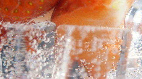 Close up of rotating fresh sliced fruit in glass with water and ice cubes. 4k ma Stock Footage 108061946