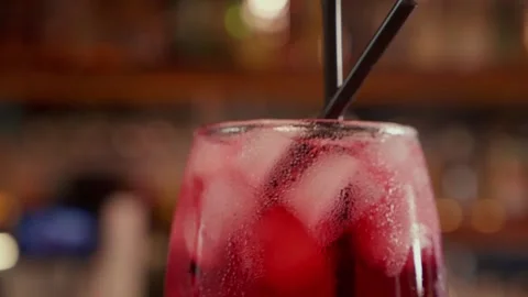 Close-up of rotating glass with Red syrup or alcohol coctail on the Bar stand Stock Footage 259426882
