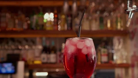Close-up of rotating glass with Red syrup or alcohol coctail on the Bar stand Stock Footage 260225431