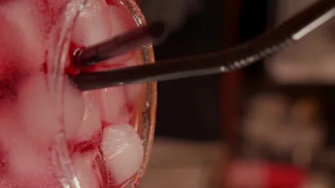Close-up of rotating glass with Red syrup or alcohol coctail on the Bar stand Stock Footage 260714923