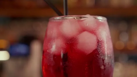 Close-up of rotating glass with Red syrup or alcohol coctail on the Bar stand Stock Footage 260715924