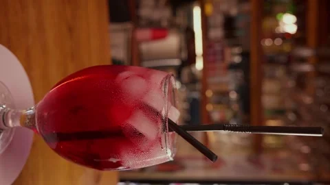 Close-up of rotating glass with Red syrup or alcohol coctail on the Bar stand Stock Footage 260716101