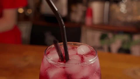 Close-up of rotating glass with Red syrup or alcohol coctail on the Bar stand Stock Footage 262484668
