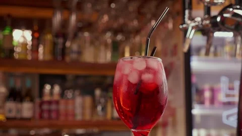 Close-up of rotating glass with Red syrup or alcohol coctail on the Bar stand Stock Footage 264679923