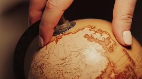 Close-up of a rotating globe with continents depicted. A child is learning about Stock Footage 309519121