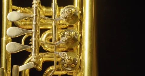 Close Up of a Rotating Golden Saxophone in front of a Black Background  Vidéo 129337580