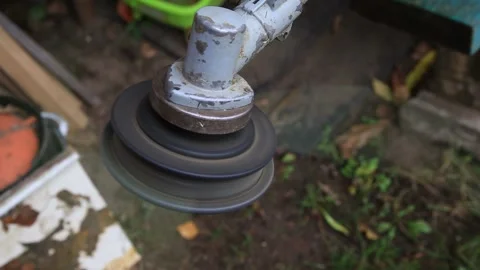 Close-up rotating head of weed trimmer machine in motion, outdoor garden Stock-Footage 329213212