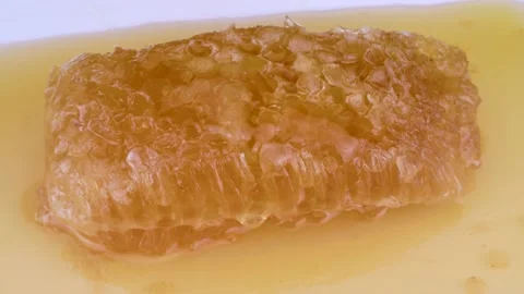 Close-up of rotating honey dripping and Pouring on honeycomb. macro shot Stock Footage 231738154