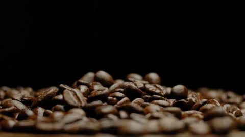 Close-up of rotating hot roasted coffee beans against a black background. Stock Footage 295652772