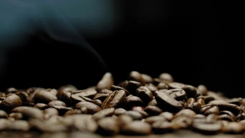 Close-up of rotating hot roasted coffee beans against a black background. Video stock 295653211