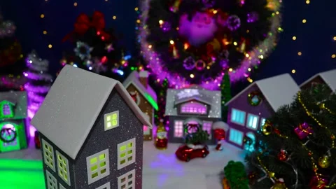 A close-up of a rotating house in front of a large decorated Christmas village Stock-Footage 319895957