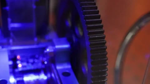 Close Up of Rotating Metal Gears Under Vibrant Blue Lighting Stock Footage 327425975