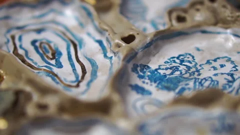 Close-up of a rotating oven-ready ceramic product with a blue pattern Stockbeeldmateriaal 256324110