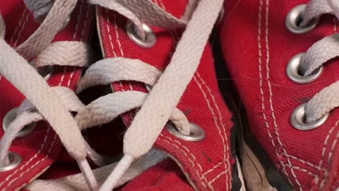 Close-up of rotating pair of red used sneakers Converse with white laces. Stock Footage 140487737