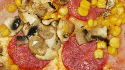 Close up rotating pizza with ham, salami, corn, mushrooms Stock Footage 195952988