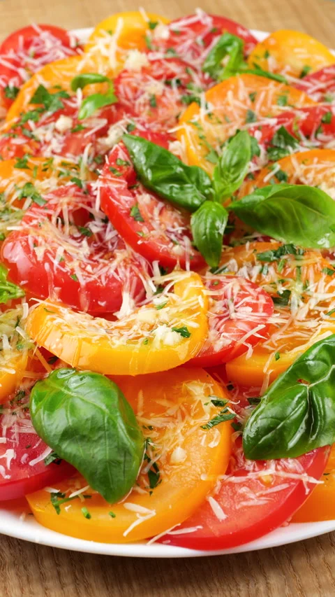 Close-up of a rotating plate filled with fresh red and yellow tomato slices. Stock-Footage 341489508