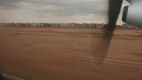 Close-up of rotating propeller from window of airplane taking off and rows of Stock Footage 264843044