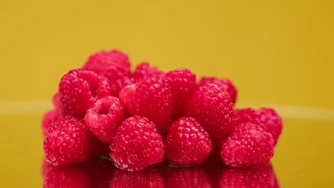 Close-up of rotating ripe red raspberry isolated on yellow background, making Stock Footage 158679799