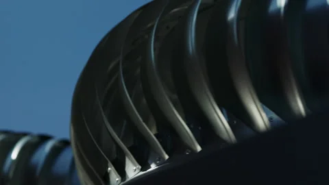 Close up of rotating rooftop turbine ventilator against blue sky Stock Footage 346550879