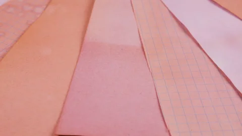 Close-up of rotating sheets of handmade paper in warm peach, soft coral. Stock-Footage 330251161
