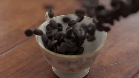 Close up rotating shot of Coffee beans falling into a cup in slow motion Stock Footage 253626848
