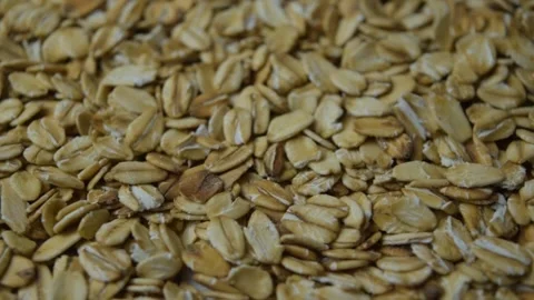 Close-up rotating shot of dry rolled oat flakes on a white turntable background Vidéo 346520622