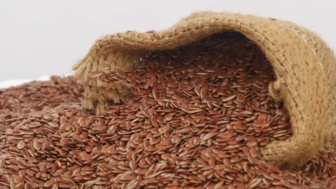 Close rotating shot shot of flax seeds placed over white background Vidéo 147855557