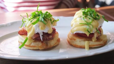 Close-up rotating shot of two pancake servings topped with poached egg Stock Footage 332159253