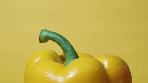 Close up of rotating sweet pepper on yellow background Stock Footage 98737276