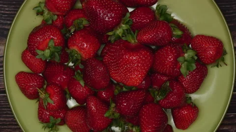 Close Up Rotating Top View Ripe Summer Red Strawberries On Green Plate With Wood Stock-Footage 155936915