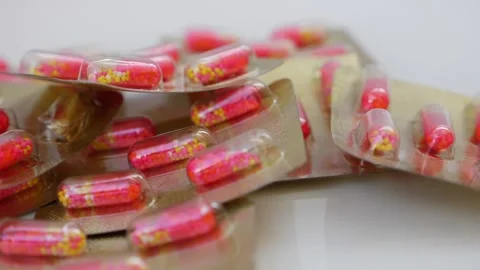 Close rotating view of pink and white granule capsule, footage of granule cap Vídeo Stock 147699238