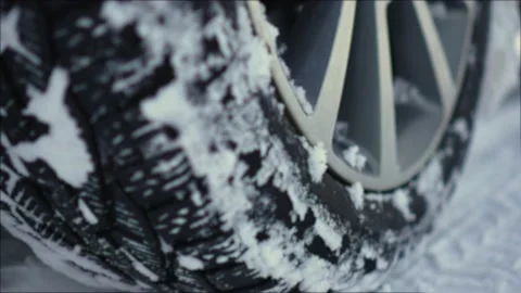 Close up rotating wheels of car with deep tread spinning by untreated from snow Vidéo 233084835