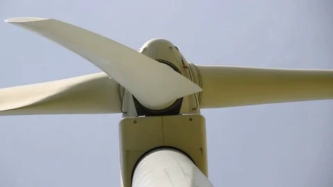 Close up of rotating wind turbine propeller blades in the blue sky Stock Footage 75535189