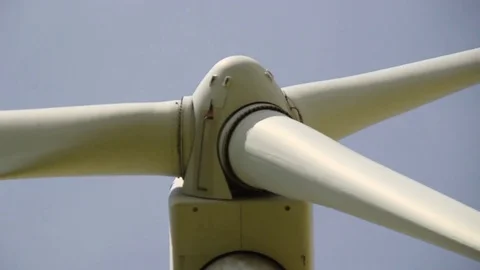 Close up of rotating wind turbine propeller blades in the blue sky Stock Footage 75535216