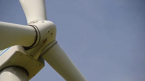 Close up of rotating wind turbine propeller blades in the blue sky Stock Footage 75536546