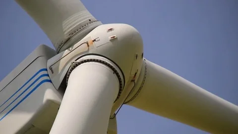 Close up of rotating wind turbine propeller blades in the blue sky Stock Footage 75536581