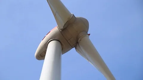 Close up of rotating wind turbine propeller blades in the blue sky Stock Footage 75538456